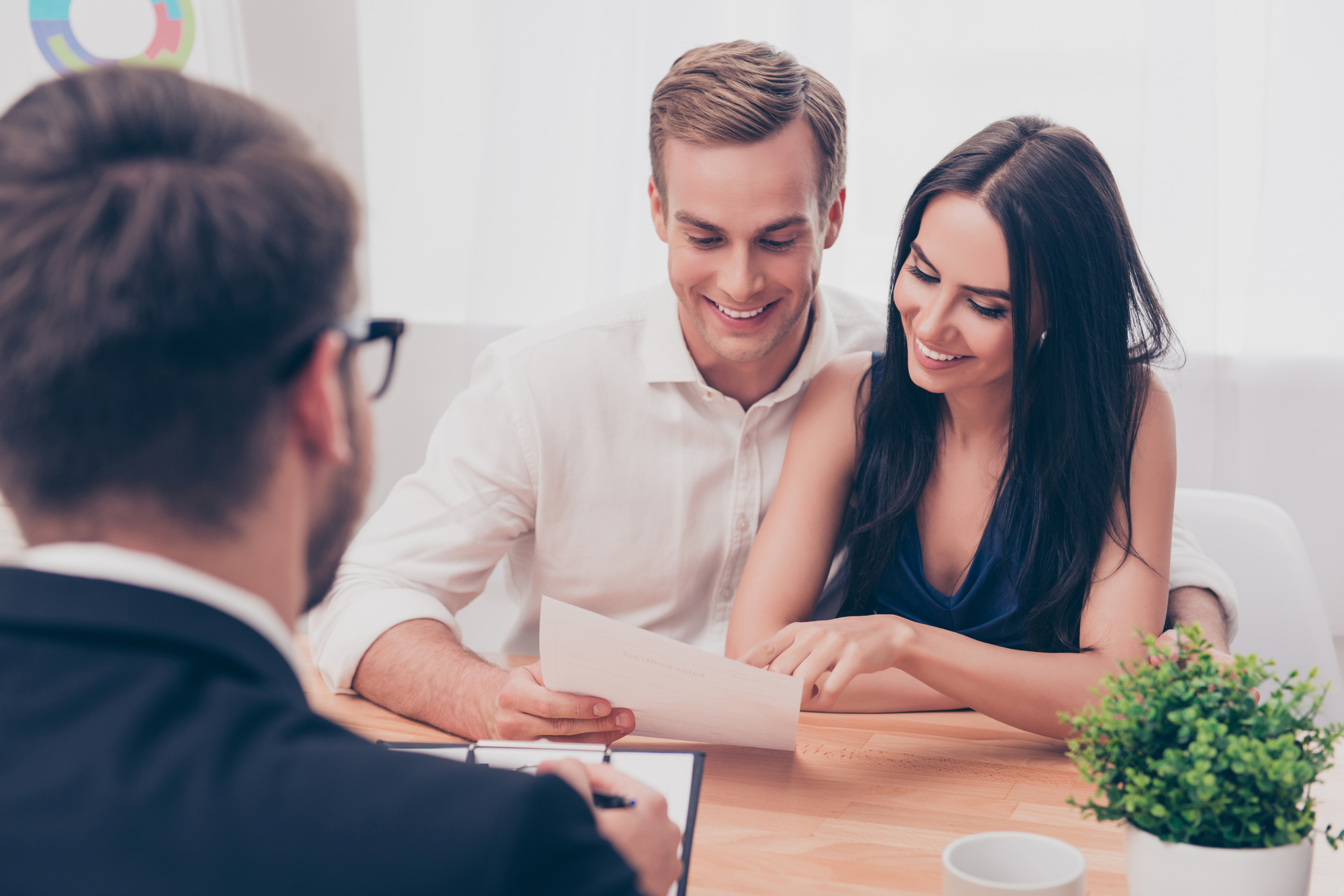 Couple With Realtor Discussing Contract Terms